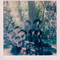 a group of women posing in front of a tree