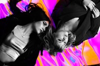 two women laying on top of a colorful background