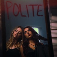 two women standing in front of a mirror with the word pollie written on it